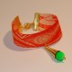 Bracelet tissu plumes orange avec un cône doré et une perle verte fluo